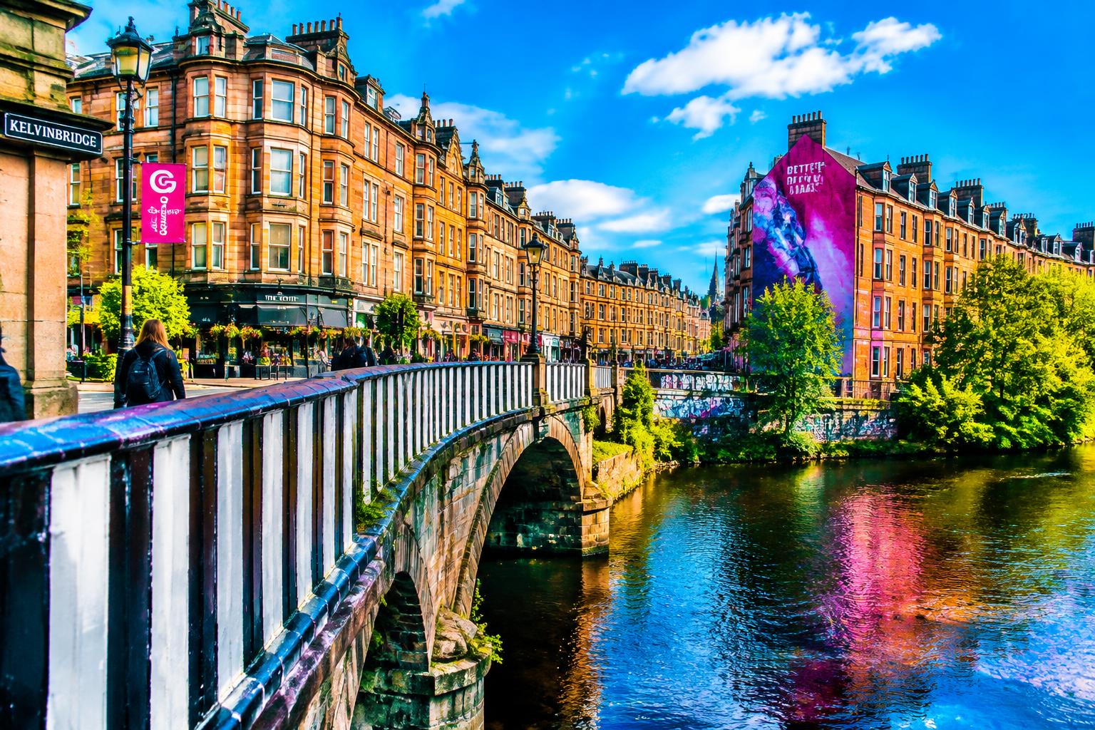 Kelvinbridge, Glasgow, with stone buildings, colourful street art and reflections in the River Kelvin